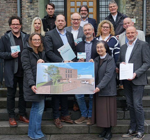 Stellten am Freitag in Salzkotten die Pläne für ein innovatives Wohnprojekt für Frauen mit Unterstützungsbedarf vor (v.l.): vorne: Susann Wellie (Wellie Architekten Partner), Marco Schmitz (MdL) (Stiftungsratsvorsitzender der Sozialstiftung NRW), Franz-Josef Knust (SkF Paderborn e.V.), Schwester M. Angela Benoit (Provinzoberin Franziskanerinnen Salzkotten), Andreas Cramer (Verwaltungsdirektor Franziskanerinnen Salzkotten), mittlere Reihe: Michael Nölle (Wellie Architekten Partner), Rita Wienstroer (SkF Paderborn e.V.), Bernhard Hoppe-Biermeyer (MdL), Cornelia Schmiegel (SkF Paderborn e.V.), Hermann Hengstermann (Berater der Franziskanerinnen Salzkotten), hintere Reihe: Axel Ziers (Wellie Architekten und Partner), Rainer Janssen (Bauministerium NRW MHKBD), Hubert Robrecht (Kreis Paderborn). Foto: Michael Bodin / Franziskanerinnen Salzkotten